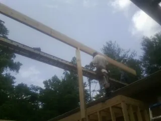 Carpenter setting a ridge beam over a new addition frame — Ice Dam Removal by Roofing Brothers in Elk Horn