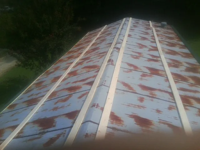 Rusted metal roof panels with new wood purlins before replacement — Storm Damage Roof Repair in Elk Horn by Roofing Brothers