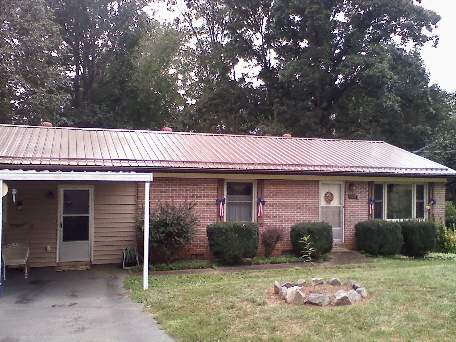 Bronze metal roof and carport on a brick ranch home — Roof Repair work by our crew in Elk Horn